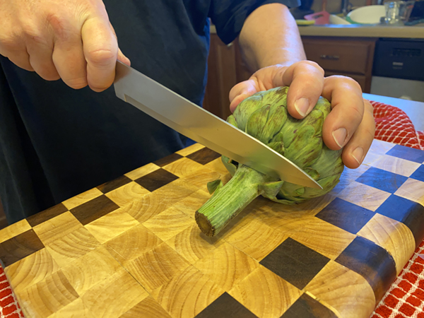 Cutting off the stem of the artichoke
